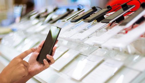 Person testing a smartphone at a retail store